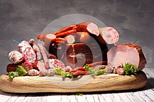 Cold meat assortment with delicious salami and  fresh herbs . Variety of meat products including proscuitto, jamon  and sausages