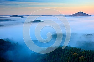 Cold misty foggy morning in a fall valley of Bohemian Switzerland park. Hills with fog, landscape of Czech Republic