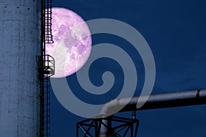 cold moon back over silhouette refinery oil tank