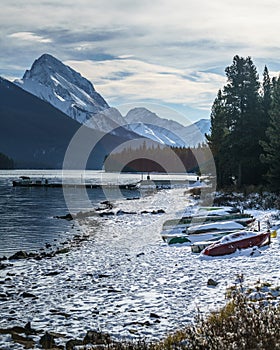 Cold morning with snow covering canoes in maligne lake, alberta, canada