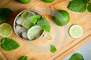 Cold Moscow Mule cocktail in copper mug on the rustic background