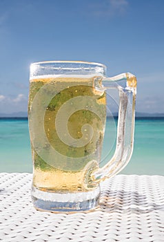 Cold mug of beer on the table at the beach restaurant