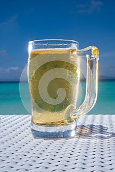 Cold mug of beer on the table at the beach restaurant