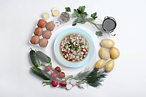 Cold okroshka with kvass and ingredients on white background, top view. Traditional Russian summer soup