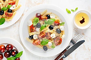 Cold pasta salad with fussili, cherry tomatoes, mozzarella cheese and olives