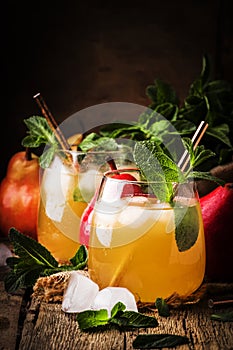 Cold pear juice, iced summer non-alcoholic cocktail with mint, old wooden table background, selective focus