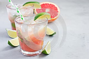 Cold pink cocktail with fresh grapefruit, lime, copy space