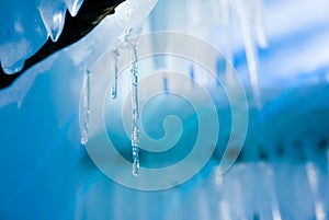 Cold pleasant icicles background with warm light reflections