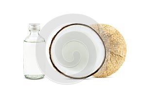 Cold pressed coconut oil in bottle with fresh coconuts on white background