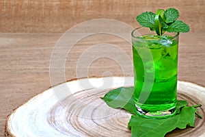 Cold and refreshing lime and mint green water in a glass on wood