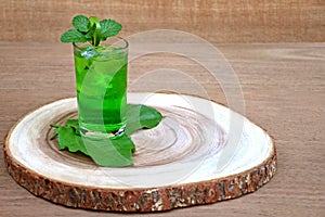 Cold and refreshing lime and mint green water in a glass on wood