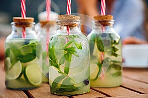 Cold refreshing limonade, mojito or gin tonic in glass, with fresh mint and ice cubes