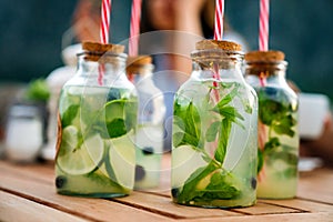 Cold refreshing limonade, mojito or gin tonic in glass, with fresh mint and ice cubes