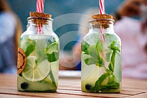 Cold refreshing limonade, mojito or gin tonic in glass, with fresh mint and ice cubes