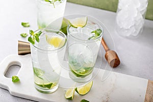 Cold refreshing mojito with lime and mint in tall glasses