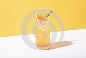 Cold and refreshing orange punch cocktail with orange slice on yellow background. summer drink