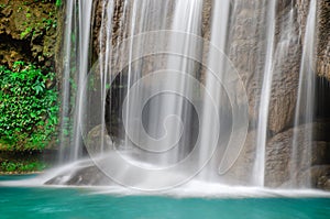 Cold river waterfall cascade falling down on stones, Clean blue water flows on cascades of Erawan park in Thailand