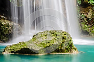 Cold river waterfall cascade falling down on stones, Clean blue water flows on cascades of Erawan park in Thailand