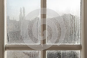 Cold room interior looking out onto water condensation on a bedroom window.