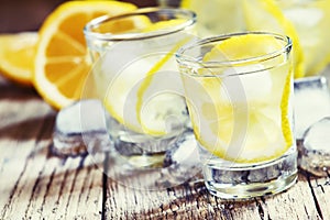 Cold Russian vodka with lemon and ice in shot glass, vintage woo