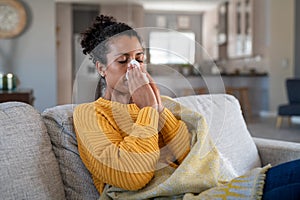 Cold sick african woman blowing nose