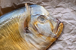 Cold smoked fish vomer on crumpled parchment on the table close-up. Top view