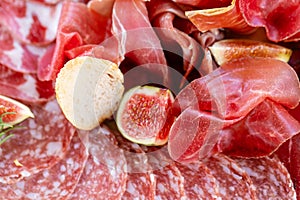 Light Italian snacks. A buffet table at a dinner party. Food tray with delicious salami, pieces of sliced ham, sausage