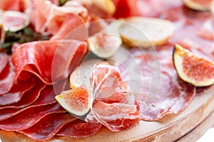 Light Italian snacks. A buffet table at a dinner party. Food tray with delicious salami, pieces of sliced ham, sausage