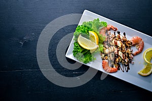 Cold snacks. Seafood, shrimp, mussels, squid, octopus. On a wooden background.