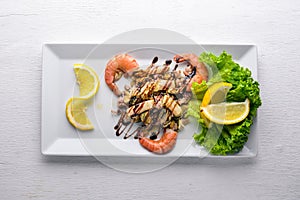 Cold snacks. Seafood, shrimp, mussels, squid, octopus. On a wooden background.