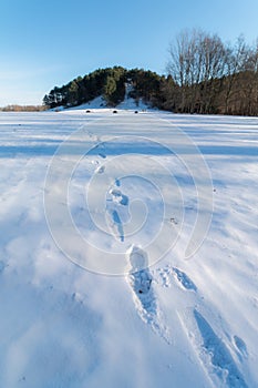 Cold snowy winter in Vallensbaek Denmark - footsteps in snow towards a hill