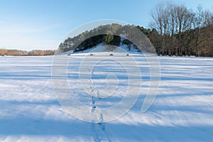 Cold snowy winter in Vallensbaek Denmark - footsteps in snow towards a hill