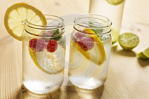 Cold soda in glass jar with lemon and berries