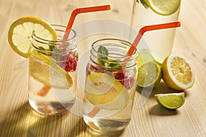 Cold sodas with lemon and berries in jar on a wood