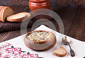 Cold Soup Okroshka in bowl and raw ingredients on wooden table