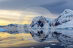 Cold still water of antarctic lagoon with glaciers and mountains