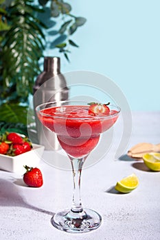 Cold strawberry margarita or daiquiri cocktail with lime and rum