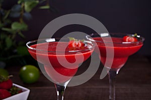 Cold strawberry margarita or daiquiri cocktail with lime and rum