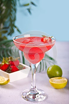 Cold strawberry margarita or daiquiri cocktail with lime and rum