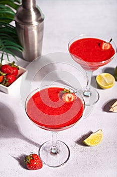 Cold strawberry margarita or daiquiri cocktail with lime and rum