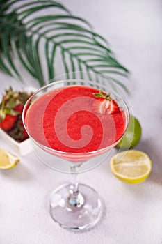 Cold strawberry margarita or daiquiri cocktail with lime and rum