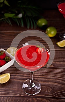 Cold strawberry margarita or daiquiri cocktail with lime and rum