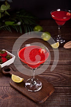 Cold strawberry margarita or daiquiri cocktail with lime and rum