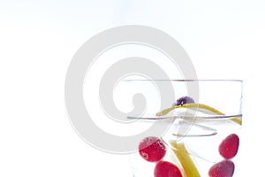 Cold Summer refreshing cocktail with lemon pieces of ice and berries. photo summer drink close-up on a white background.