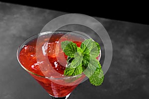 Cold summer strawberry cocktail mojito, margarita, daiquiri in a martini glass on dark background, close up