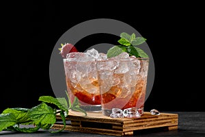 Cold summer strawberry iced cocktail mojito, margarita, daiquiri in two glasses with mint leaves on dark background
