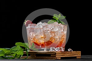 Cold summer strawberry iced cocktail mojito, margarita, daiquiri in two glasses with mint leaves on dark background