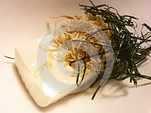 Cold tofu with seaweed and dry fish in a local restaurant, traditional Japanese food, appetizer dish, closed up