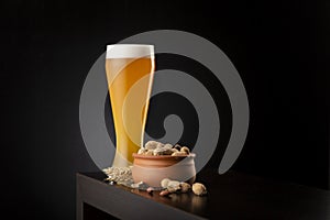 Cold unfiltered wheat beer and peanuts photo