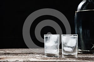 Cold vodka in shot glasses on a black background